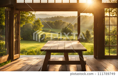 An empty wooden table in the foreground, with a blurred country house in the background against a verdant garden setting 111789749