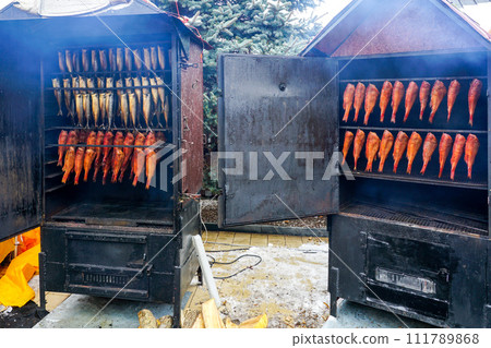 Opened smokehouses with fresh hot-smoked red sea bass and mackerels 111789868