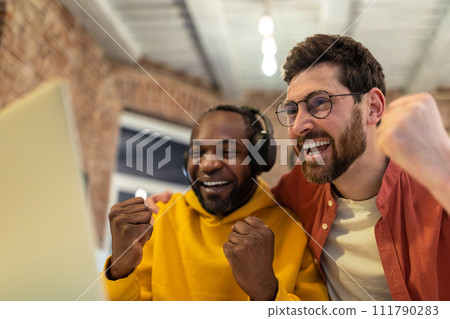 Two colleagues working together and looking excited 111790283