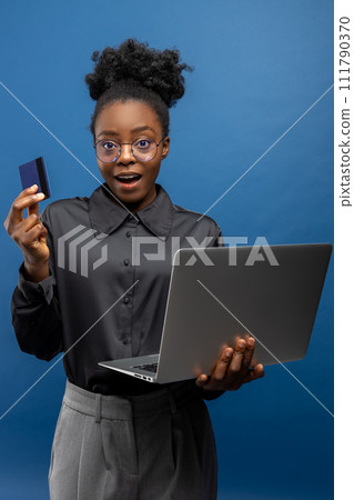 African american business woman with a credit card and a laptop in hands 111790370