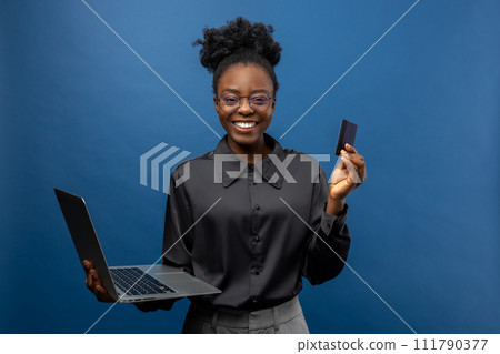 African american business woman with a credit card and a laptop in hands African american business woman with a credit card and a laptop in hands 111790377