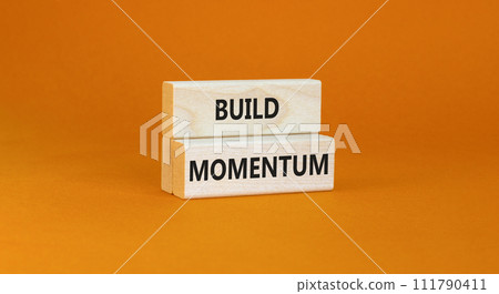 Build momentum symbol. Concept words Build momentum on wooden blocks. Beautiful orange table orange background. Business and build momentum concept. Copy space. Build momentum symbol. Concept words Build momentum on wooden blocks. Beautiful orange table orange background. Business and build momentum concept. Copy space. 111790411
