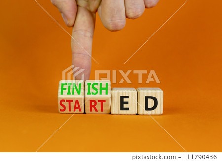 Started and finished symbol. Businessman turns beautiful wooden cubes and changes word Started to Finished. Beautiful orange table orange background. Business started and finished concept. Copy space. 111790436