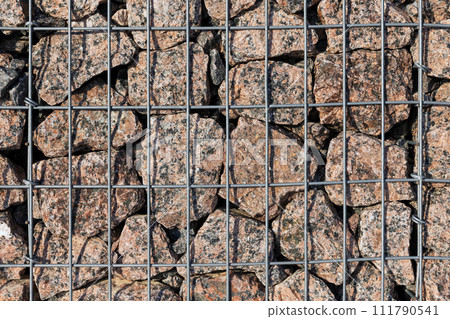 Close up photo texture of gabion wall, steel cages filled with stones Close up photo texture of gabion wall, steel cages filled with stones 111790541