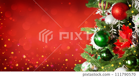 Christmas tree with ornaments and balls on red background with bokeh lights. Merry Christmas and a happy New Year greeting card. Christmas tree with ornaments and balls on red background with bokeh lights. Merry Christmas and a happy New Year greeting card. 111790570