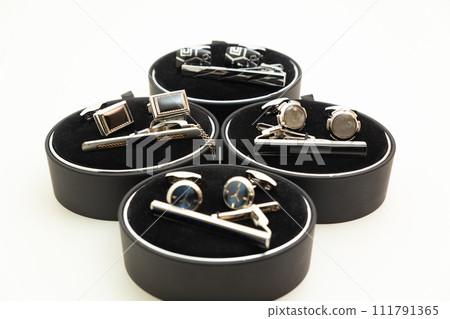 Sets with cufflinks and tie clips on white background. 111791365