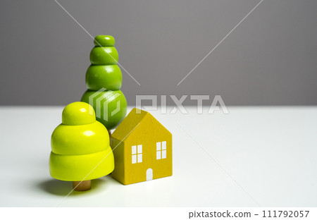 House and green trees. Environmental friendliness and harmony with nature. Eco house. Autonomy and closeness with nature. Wooden figures 111792057