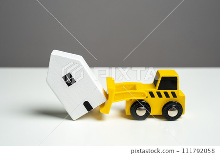 Demolition of a house with a bulldozer. The bulldozer intends to demolish the house. Making way for future developments. Territory clearing service. 111792058