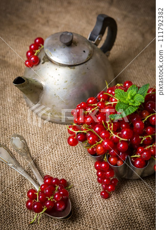 juicy currant berries on burlap near an old teapot juicy currant berries on burlap near an old teapot 111792382
