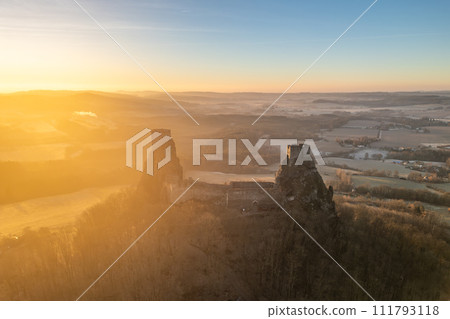 Trosky medieval castle ruins at cold morning sunrise time. Bohemian Paradise, Czech: Cesky raj, Czechia. Aerial view from above. 111793118