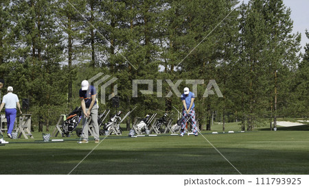 Golfers hit sweeping golf course in the summer. The game of Golf 111793925