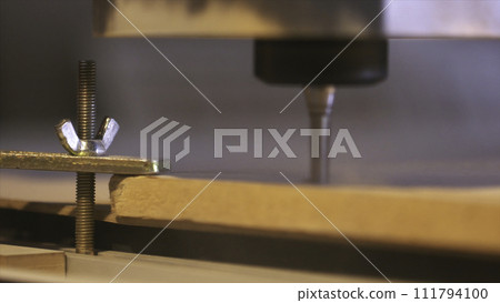 Close-up of wood cutting machine controlled by computer while he is carving wood. Action. CNC milling machine carving a wooden part blank. 111794100