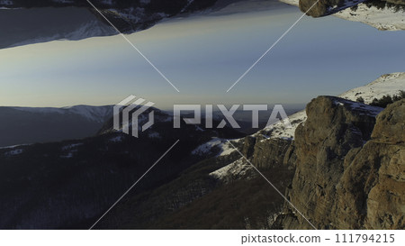 Aerial of snowy inaccessible and very high peaks of the mountains in the northeastern part of Italy on a winter sunny day. Shot. Surreal upside down mirrored world, inception theme. Aerial of snowy inaccessible and very high peaks of the mountains in the northeastern part of Italy on a winter sunny day. Shot. Surreal upside down mirrored world, inception theme. 111794215