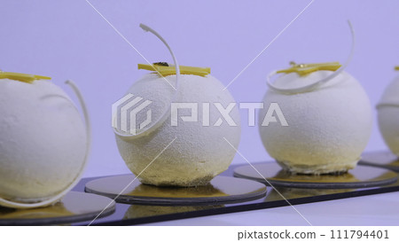 Velvet cake balls with sugar sprinkles. White, ball-shaped cakes. Decorative white cakes Velvet cake balls with sugar sprinkles. White, ball-shaped cakes. Decorative white cakes 111794401