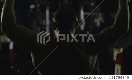 Sportsman athlete bodybuilder trains in the gym. Handsome muscular sports man in fitness club, top view. Fighter Sportsman athlete bodybuilder trains in the gym. Handsome muscular sports man in fitness club, top view. Fighter 111794549