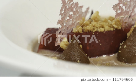 Salad of baked beets, arugula, cheese and nuts. Fresh salad with beets and oranges, food. Vegetarian lean lettuce from beet, onion, walnuts, serving on a white plate close up 111794606