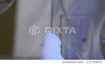 Chemical reaction in volumetric flask glass in laboratory. The chemical pink reagent in a transparent bottle. Chemical reaction close up Chemical reaction in volumetric flask glass in laboratory. The chemical pink reagent in a transparent bottle. Chemical reaction close up 111794635