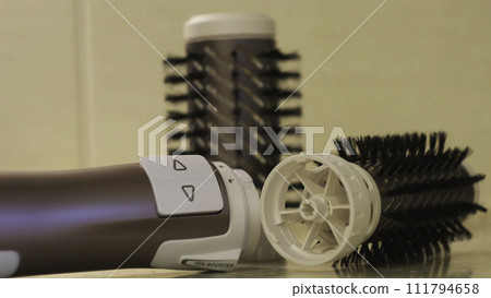 Close up of automatic dryer for hair styling, hairdresser tools and accessories. Concept. Hairdryer and nozzles: volume diffuser and round combs. Close up of automatic dryer for hair styling, hairdresser tools and accessories. Concept. Hairdryer and nozzles: volume diffuser and round combs. 111794658