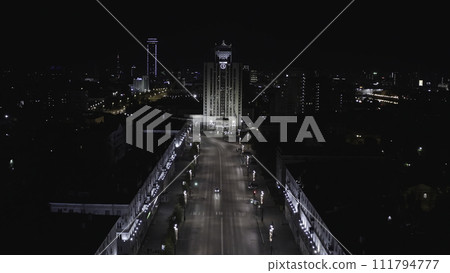 Aerial view of one of the central street in Ekaterinburg city at night. Stock footage. Flying along the houses decorated by shining lights towards the high rise building with unusual roof, concept of Aerial view of one of the central street in Ekaterinburg city at night. Stock footage. Flying along the houses decorated by shining lights towards the high rise building with unusual roof, concept of 111794777