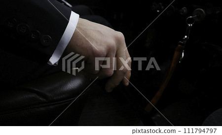 Businessman driving to work, hand shifting the gear stick. Businessman shifts the transmission in the rare machine. Businessman driving car hand shifting the gear stick. Retro style 111794797
