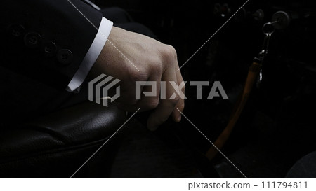 Businessman driving to work, hand shifting the gear stick. Businessman shifts the transmission in the rare machine. Businessman driving car hand shifting the gear stick. Retro style Businessman driving to work, hand shifting the gear stick. Businessman shifts the transmission in the rare machine. Businessman driving car hand shifting the gear stick. Retro style 111794811