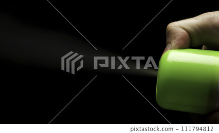 Closeup of spray can spraying aerosol insecticide or fragrance mist into the air in slow motion on black background. Air freshener on black background 111794812