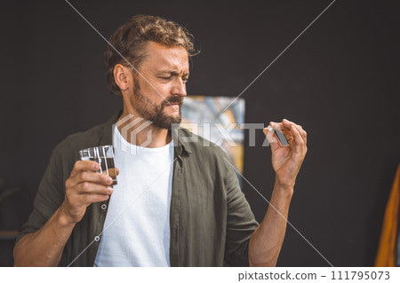 A man holding a pill or medicine in his hand. A man holding a pill or medicine in his hand. 111795073