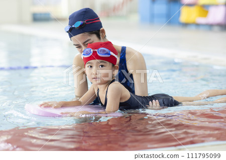 Children attending swimming school and their coach Children attending swimming school and their coach 111795099
