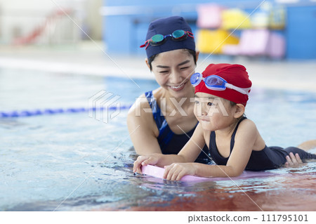 Children attending swimming school and their coach 111795101