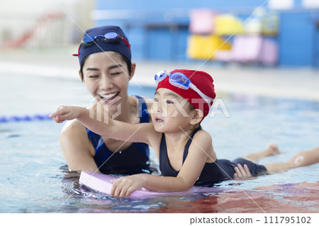 Children attending swimming school and their coach Children attending swimming school and their coach 111795102