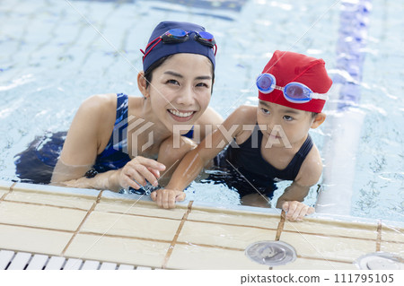 Children attending swimming school and their coach 111795105