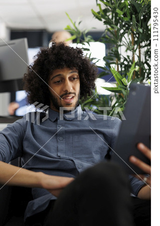 Project manager discussing deadline with coworkers in videocall on digital tablet. Young arab start up entrepreneur talking about strategy with business partner in online meeting 111795430