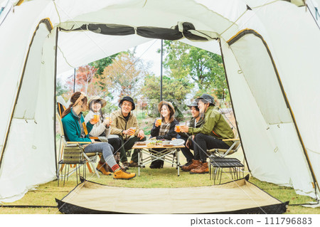 Asian men and women drinking beer and partying with friends at a campsite in autumn and winter (group camping) Asian men and women drinking beer and partying with friends at a campsite in autumn and winter (group camping) 111796883