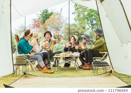 Asian men and women drinking beer and partying with friends at a campsite in autumn and winter (group camping) Asian men and women drinking beer and partying with friends at a campsite in autumn and winter (group camping) 111796884