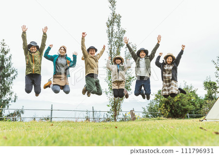 Fellows and friends jumping at the campsite in autumn and winter Fellows and friends jumping at the campsite in autumn and winter 111796931