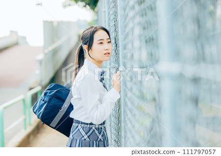 School girls wearing uniforms in front of the school building School girls wearing uniforms in front of the school building 111797057