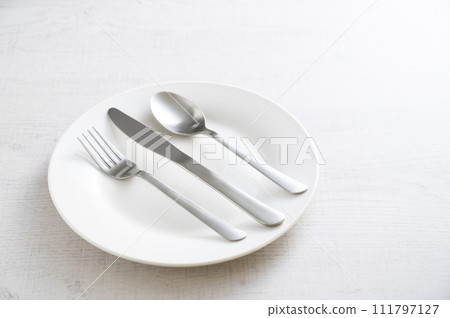 simple white plate, fork, knife and spoon simple white plate, fork, knife and spoon 111797127