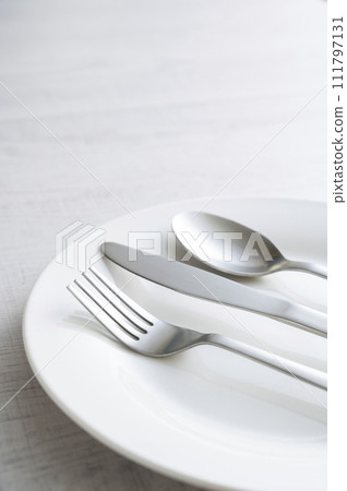 simple white plate, fork, knife and spoon simple white plate, fork, knife and spoon 111797131