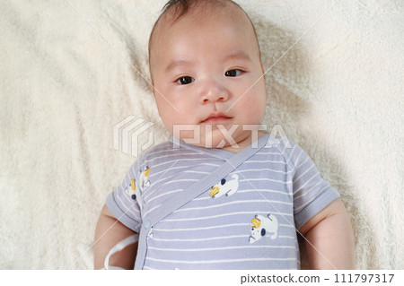 曬日光浴的嬰兒看著相機 曬日光浴的嬰兒看著相機 111797317