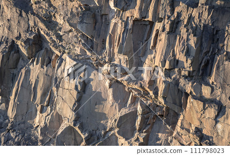 Crumbling rock cliff wall texture with cuts and shadows of The granite rock. 111798023