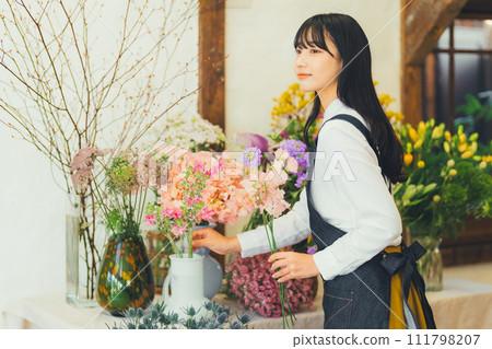 A woman working in a flower shop A woman working in a flower shop 111798207