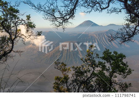 Spectacular view of Mount Bromo at dawn view look through the natural frame. This is an active volcano part of the Tengger massif, in East Java, Indonesia. 111798741