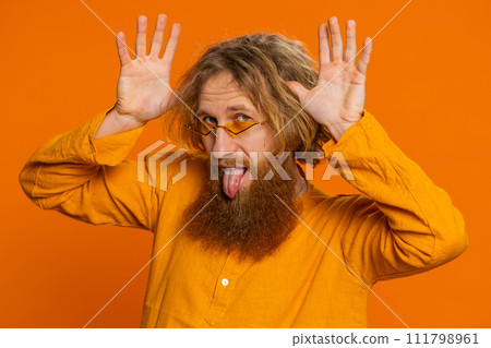 Funny comical Caucasian man making silly facial expressions grimacing fooling around showing tongue Funny comical Caucasian man making silly facial expressions grimacing fooling around showing tongue 111798961