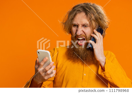 Irritated stressed business man talking on two mobile phones having conversation conflict quarrel Irritated stressed business man talking on two mobile phones having conversation conflict quarrel 111798968
