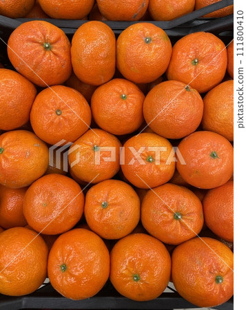 Boxes with Orange mandarins laid in rows in a supermarket or local market fruit crate. Top view Boxes with Orange mandarins laid in rows in a supermarket or local market fruit crate. Top view 111800410
