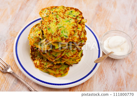 Fritters of courgettes with sour cream Fritters of courgettes with sour cream 111800770