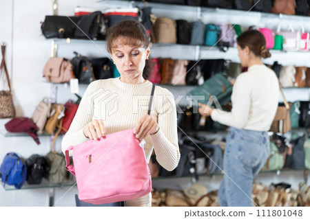 Adult woman choosing handbag in store 111801048