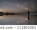 Reflection of the starry sky, sea, and silhouette of a man 111801081