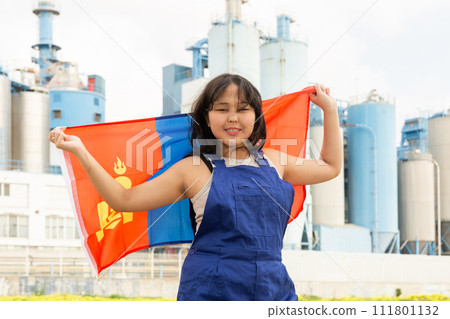 Happy young woman with flag of Mongolia against background of factory 111801132