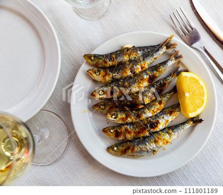 Espeto de sardinas with slice of lemon Espeto de sardinas with slice of lemon 111801189